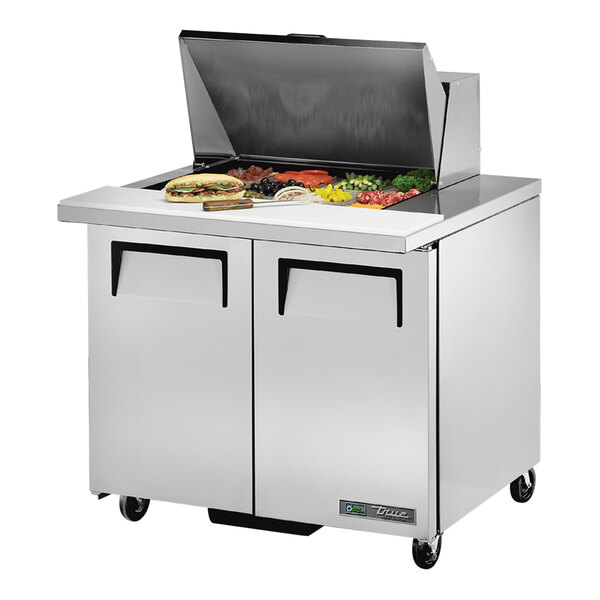 A True 2 door mega top refrigerated sandwich prep table on a counter with food.
