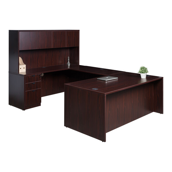 A Boss mahogany laminate desk with a hutch, bridge, and storage pedestal with a plant on it.