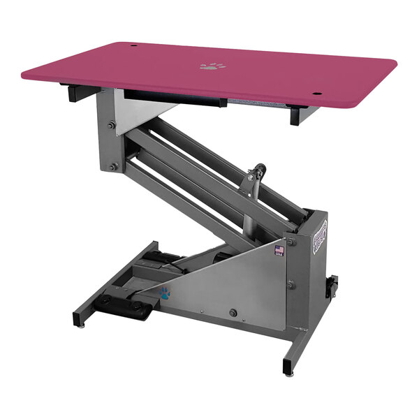 A Groomer's Best electric pink grooming table with a black metal stand.