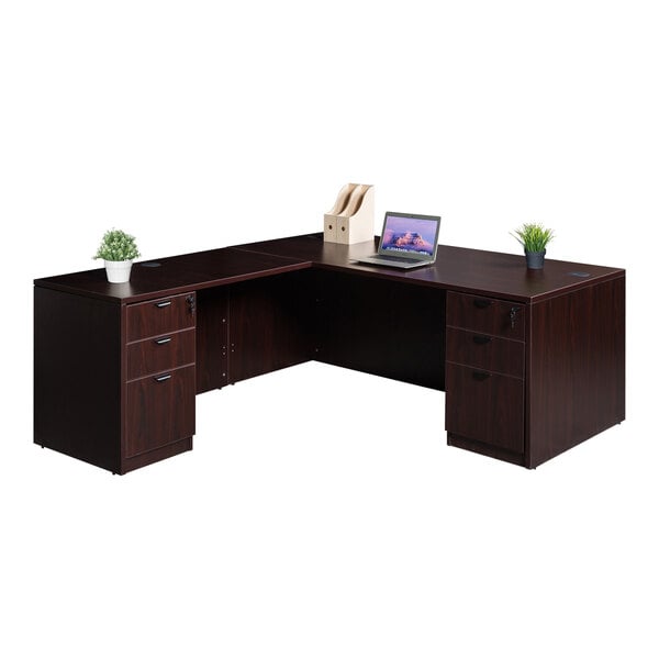 A Boss mahogany laminate L-shaped desk with a laptop on it.