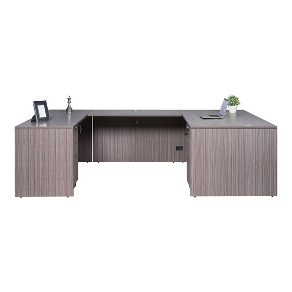 A Boss Holland driftwood laminate desk with dual storage pedestals and a laptop on top.