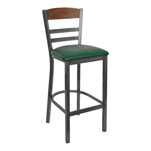 A BFM Seating steel barstool with a green vinyl seat and wood back panel.