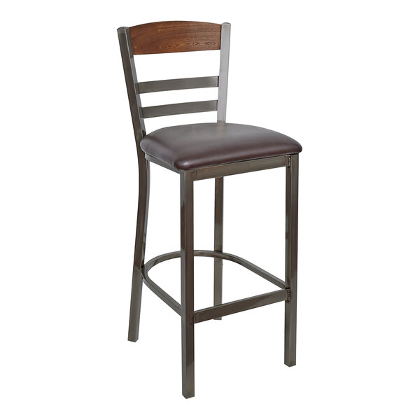 A BFM Seating metal barstool with a dark brown vinyl seat and wood back.