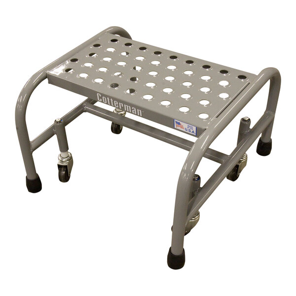 A grey metal step stool with wheels and perforated tread.