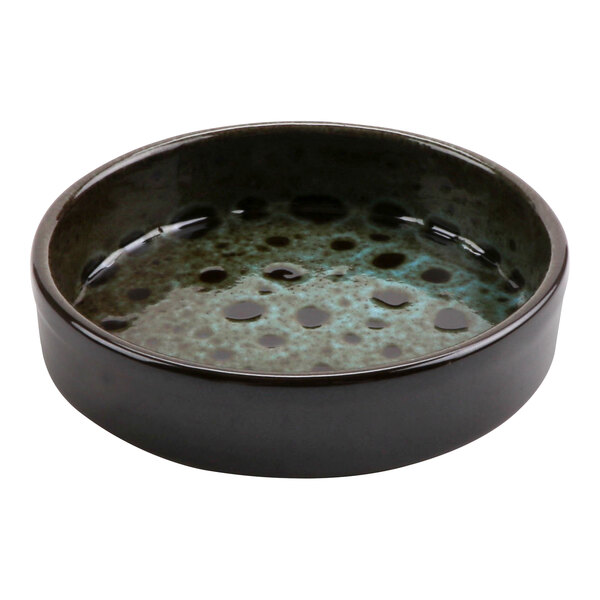 A black and blue terracotta casserole dish with a surface of bubbles and dots.