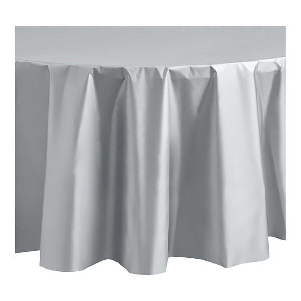 A metallic silver round plastic Table Mate tablecloth on a table.