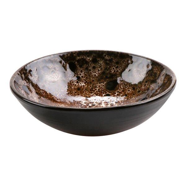 A terracotta bowl with a speckled brown and black surface and brown rim.