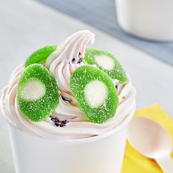 A cup of frozen yogurt with Vidal Sour Gummy Kiwis on top.