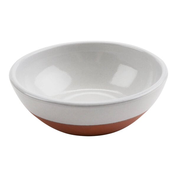A white terracotta bowl with a brown rim on a white surface.