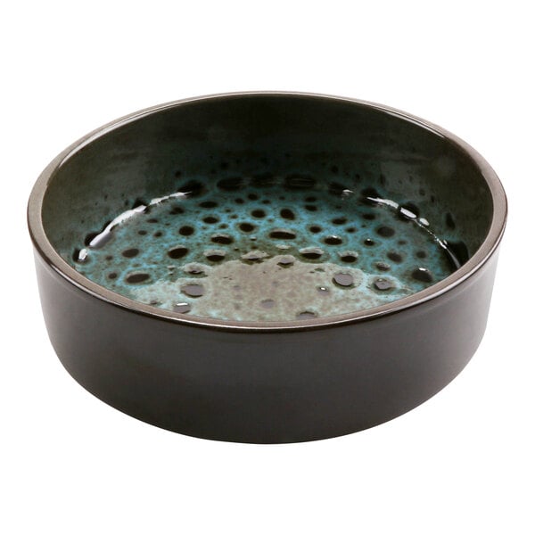 A terracotta casserole dish with a blue and black speckled surface.