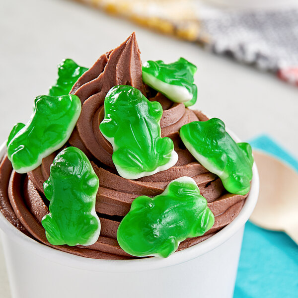 A cup of ice cream with Vidal Gummy Green Frogs on top.