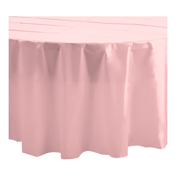 A close up of a Table Mate pink round plastic table cover with a ruffled edge.