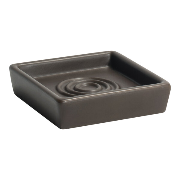 A square brown Room360 soap dish with a spiral pattern.