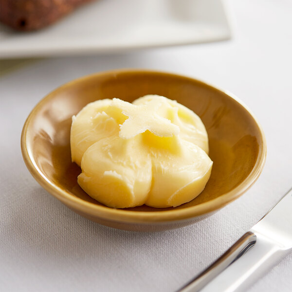 A Le Gall unsalted butter portion cup in a small bowl on a table.