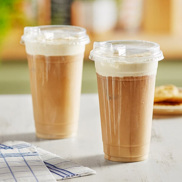 Two Choice clear plastic cups filled with brown liquid and ice.