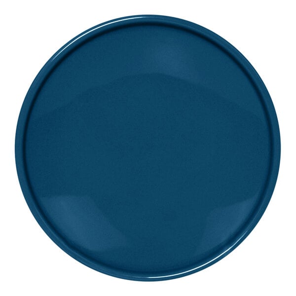 A close-up of a blue Front of the House Bevel round porcelain plate with a white circle.