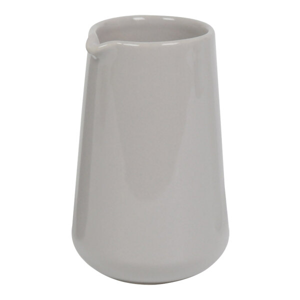 A white ceramic pourer with a handle.