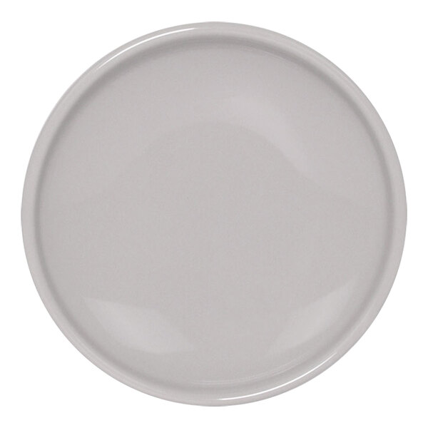 A white plate with a small round white porcelain ramekin on it.