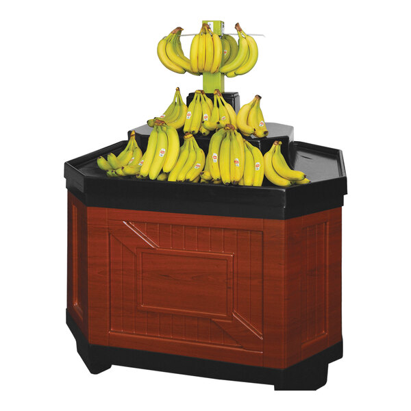 A Borray cherry plastic display for bananas on a table with a bunch of bananas with stickers.