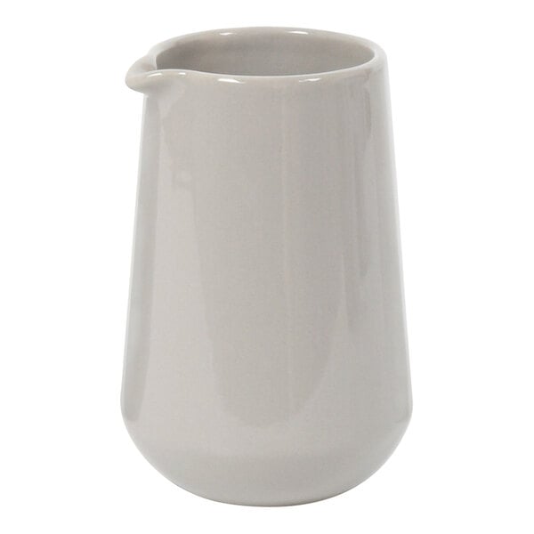 A white ceramic pitcher with a spout.