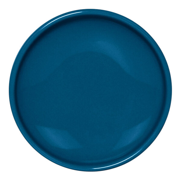 A lapis blue porcelain ramekin with a white circle on the front.