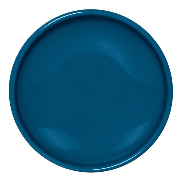 A close-up of a blue Front of the House porcelain ramekin with a rim.