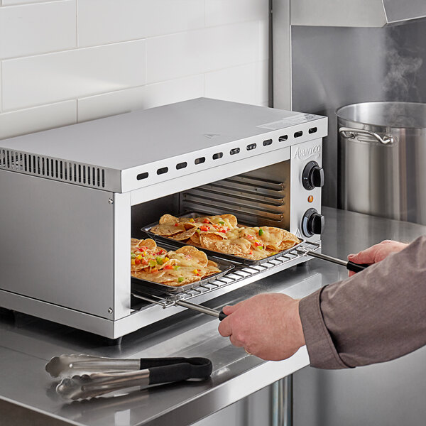 An Avantco electric countertop cheese melter cooking food in an oven.