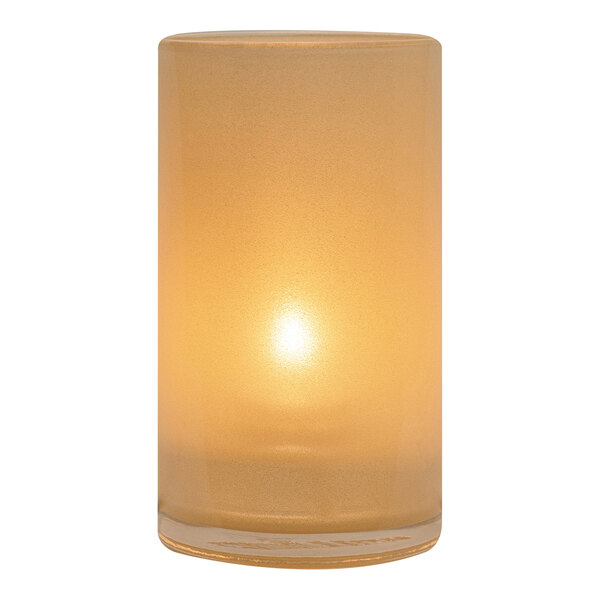 A close-up of a Satin Gold Hollowick Silo glass candle holder with a lit candle inside.