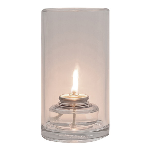 A Hollowick clear glass candle holder with a lit flame.