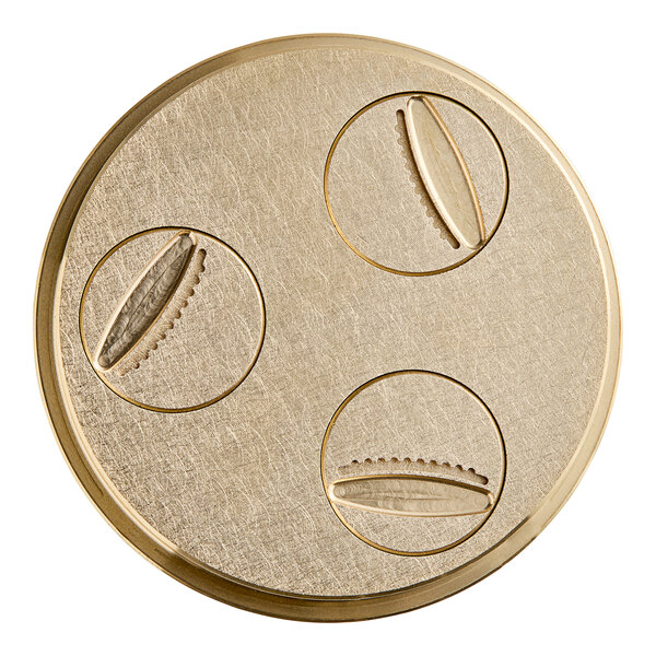 A circular gold plate with three circular objects, a 19 mm (3/4") Gnocchi pasta die with circles and a few holes.