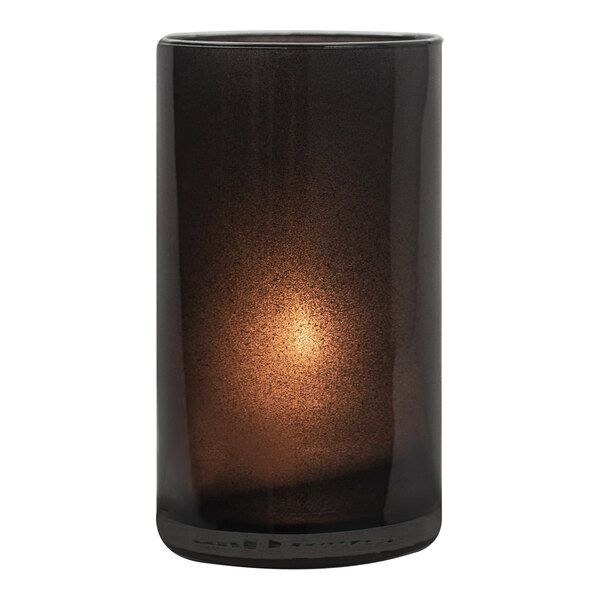 A black glass Hollowick Silo candle holder with a light shining inside.