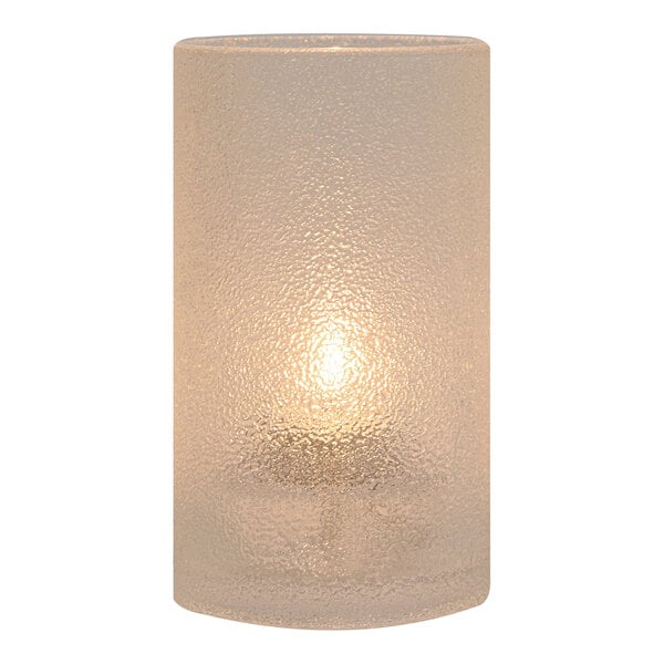 A Hollowick gold glass candle holder with a lit candle inside.