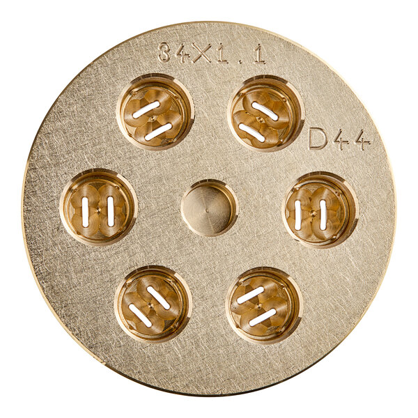 A circular gold metal object with holes in it.