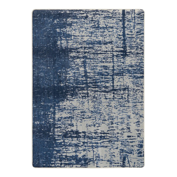A close-up of a blue and white Joy Carpets High Tide rectangle area rug with a distressed look.