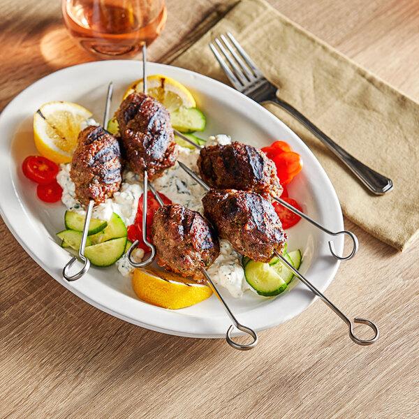 A white plate with Choice stainless steel skewers of meat and vegetables.