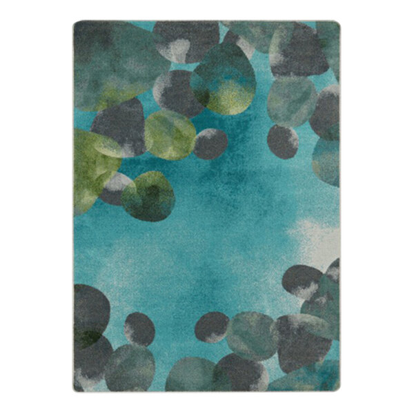 A teal area rug with blue and green circles and leaves.