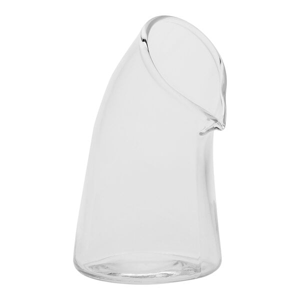 A close-up of an American Metalcraft clear curved glass creamer with a handle and curved beak.