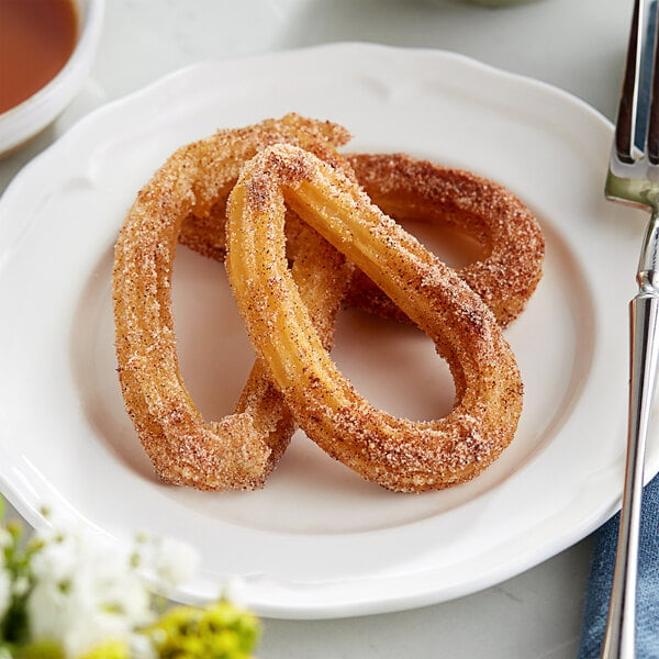Two White Toque traditional churro loops on a plate.