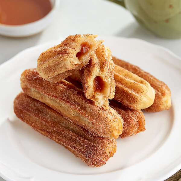 A plate of White Toque caramel filled churros with sugar on top.