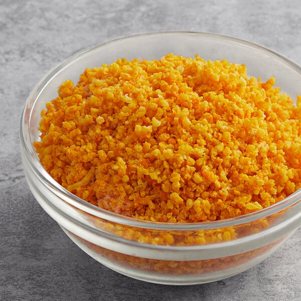 A bowl of yellow rice with White Toque Granulated Orange Zest on a table.