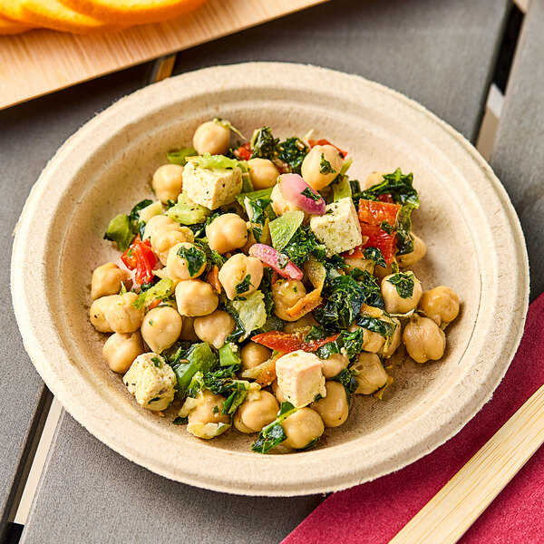 A bowl of Sunneen Krunchy Kale Salad with chickpeas and vegetables on a table in a salad bar.