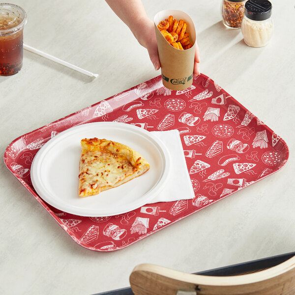 A hand holding a red Cambro fast food tray with a slice of pizza and fries.