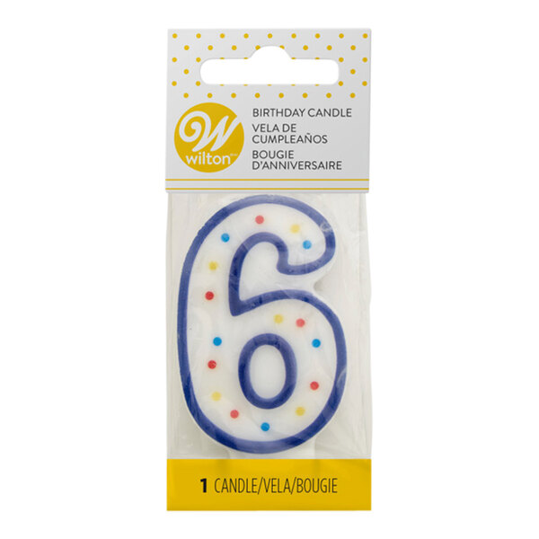 A white Wilton number six birthday candle with blue polka dots.