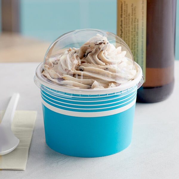 A blue Choice paper cup filled with ice cream and topped with a clear dome lid.