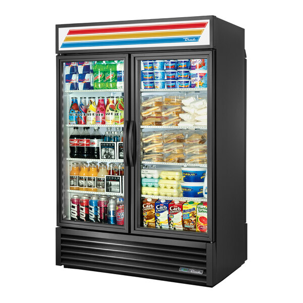 A black True Refrigerated Merchandiser with glass doors filled with drinks and beverages.