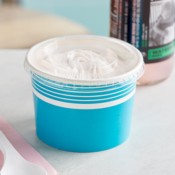 A close-up of a blue Choice paper frozen yogurt cup with a flat plastic lid.