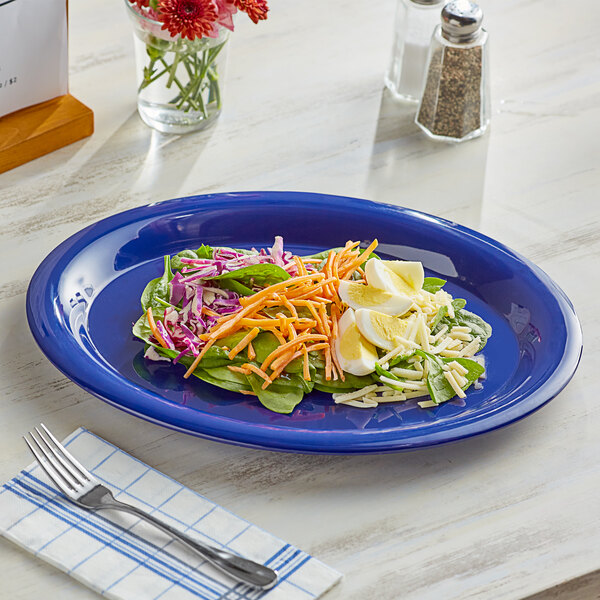 An Acopa blue melamine platter with a salad on it and a fork.