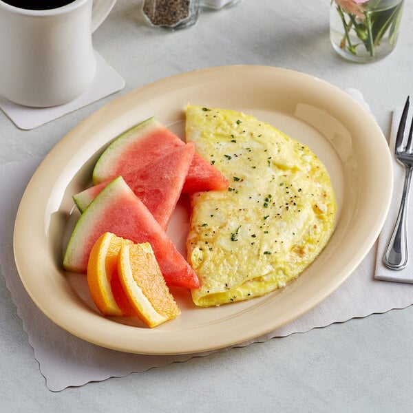 An omelet, watermelon, and orange slices on an Acopa tan melamine platter.
