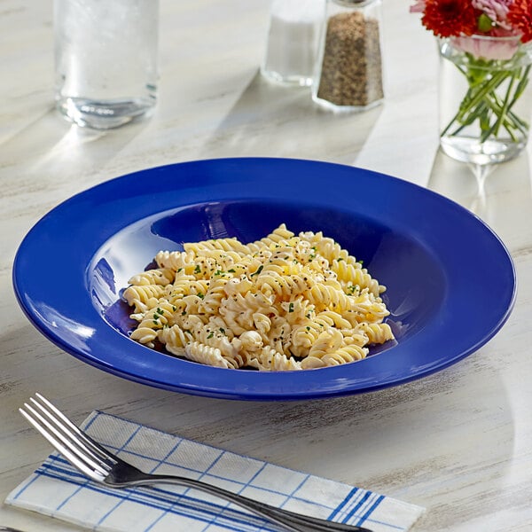An Acopa blue melamine pasta bowl filled with pasta on a table.