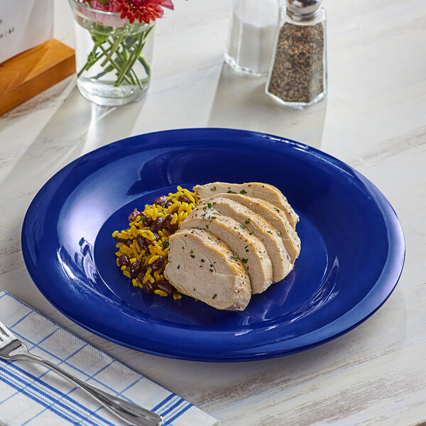 A blue Acopa Foundations wide rim melamine plate with food on it.